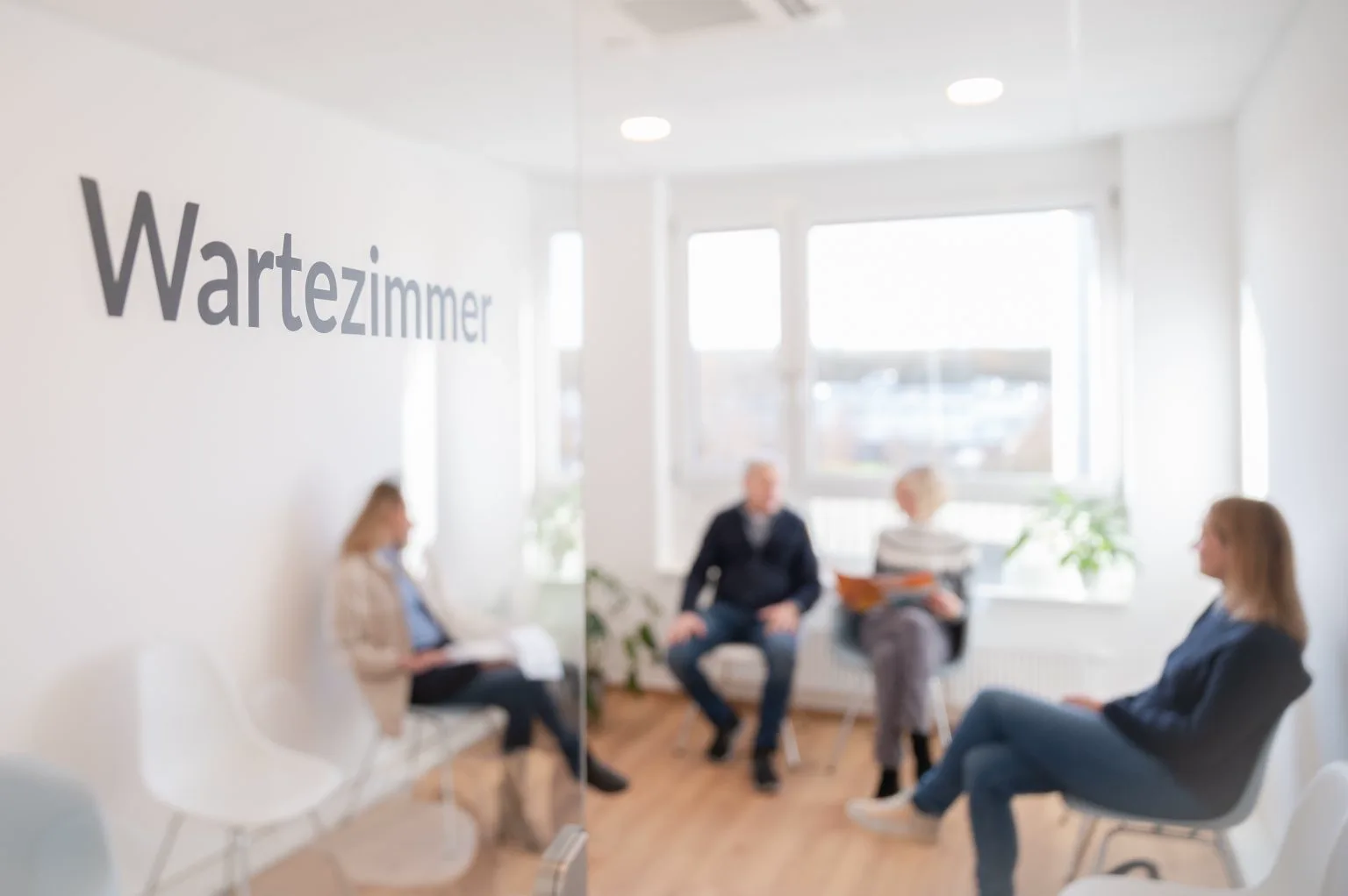 Helles Wartezimmer mit Patientinnen und Patienten